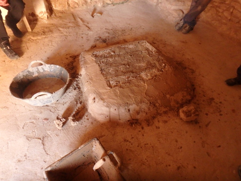 Imatge d’una llar construïda amb toves, en un espai interior, que queda sobreaixecada respecte del nivell de paviment. Està delimitada per una revora, i el conjunt està revestit de fang. Foto: projecte TRANSCOMB (ICAC).